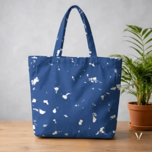 Oceanic Mist AOP Large Tote Bag by VertexVault Studio, displaying a deep blue ocean-inspired pattern shoulder bag with white sea-foam splashes on a wooden table next to a potted plant.